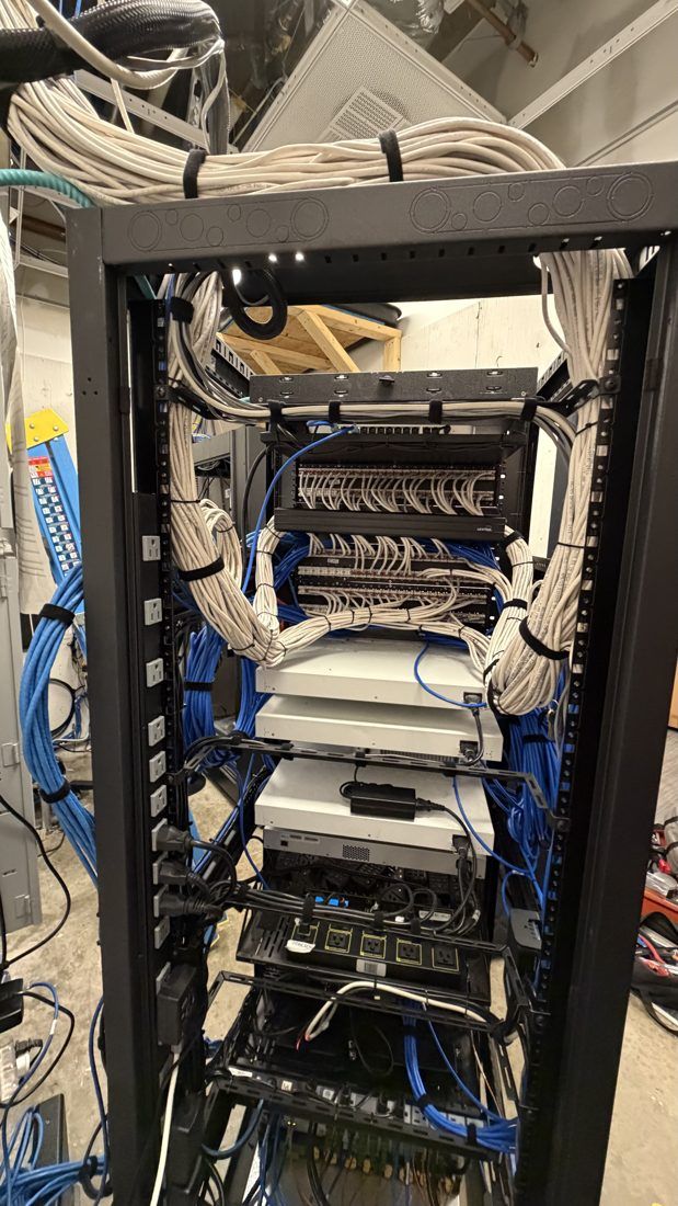 After: rear of the equipment rack with cabling bundled and laced along the rails